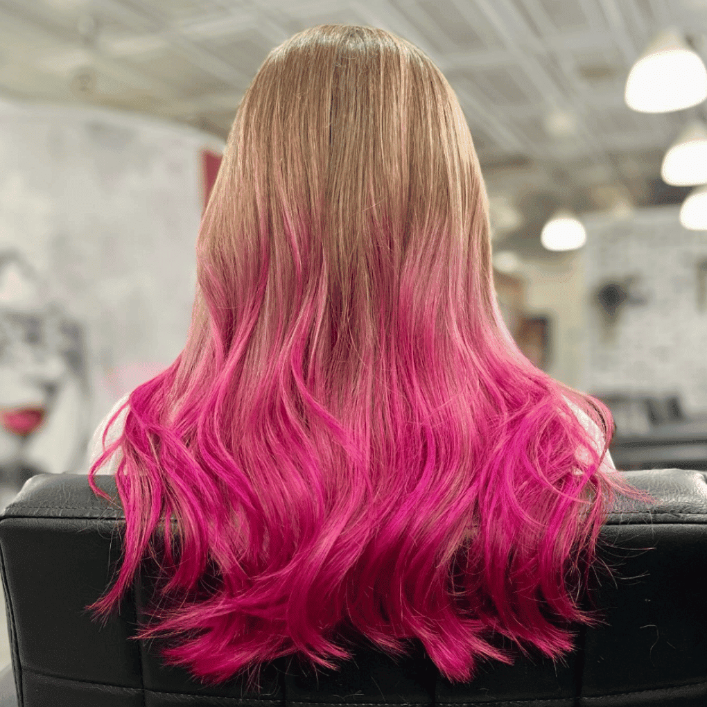 Pink ombre hair hairstyle, blonde transitioning to vibrant pink, in a salon setting.
