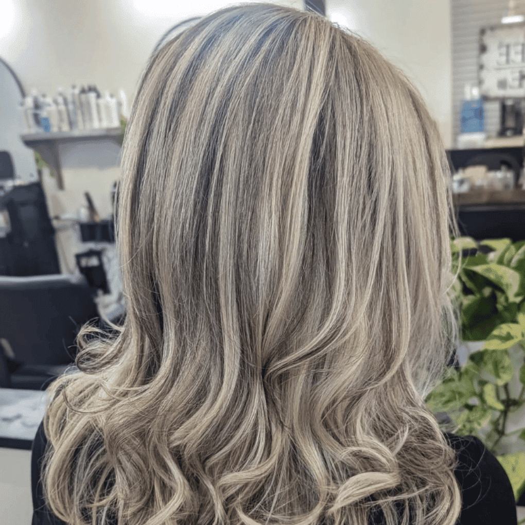 Blonde hair with soft curls in a salon setting.